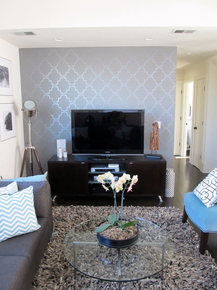 Immagine di un piccolo soggiorno moderno con pareti grigie, parquet scuro, nessun camino e TV autoportante