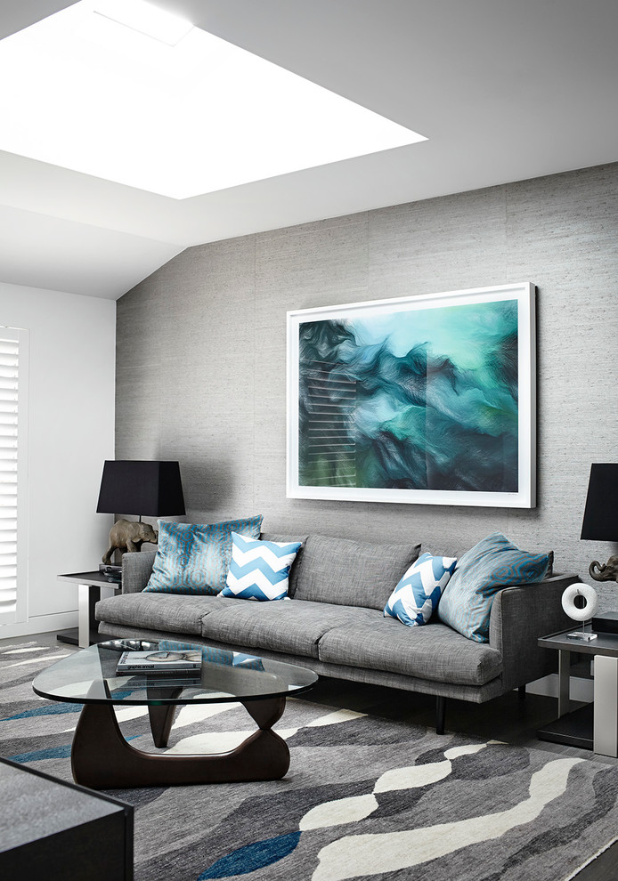 Modelo de salón para visitas cerrado minimalista grande sin chimenea con paredes grises y suelo de madera en tonos medios