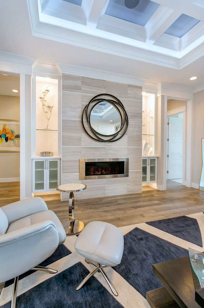 Example of a large transitional open concept light wood floor and gray floor living room design in Seattle with gray walls, a ribbon fireplace, a tile fireplace and a media wall