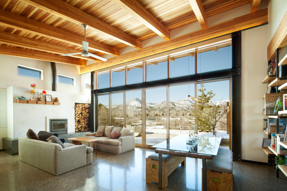 Offenes Modernes Wohnzimmer mit weißer Wandfarbe, Betonboden und grauem Boden in Denver
