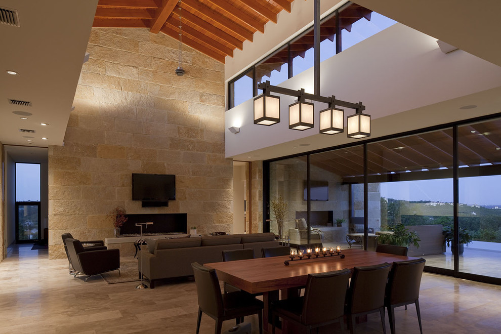 Cette image montre un grand salon design ouvert avec un téléviseur fixé au mur, un sol en calcaire, un mur beige, une cheminée ribbon, un manteau de cheminée en pierre et un mur en pierre.