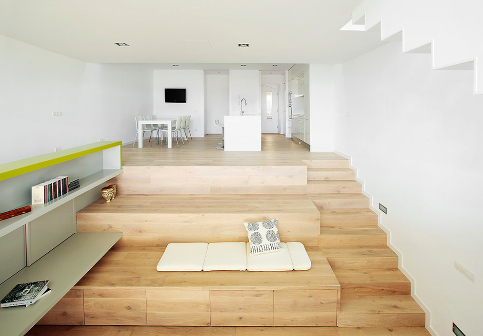 Modelo de salón abierto actual con paredes blancas y suelo de madera clara