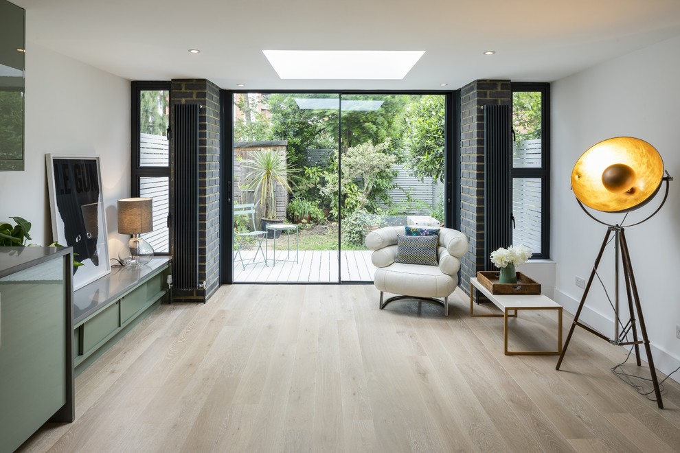 Idee per un soggiorno design con pareti bianche, parquet chiaro e pavimento beige