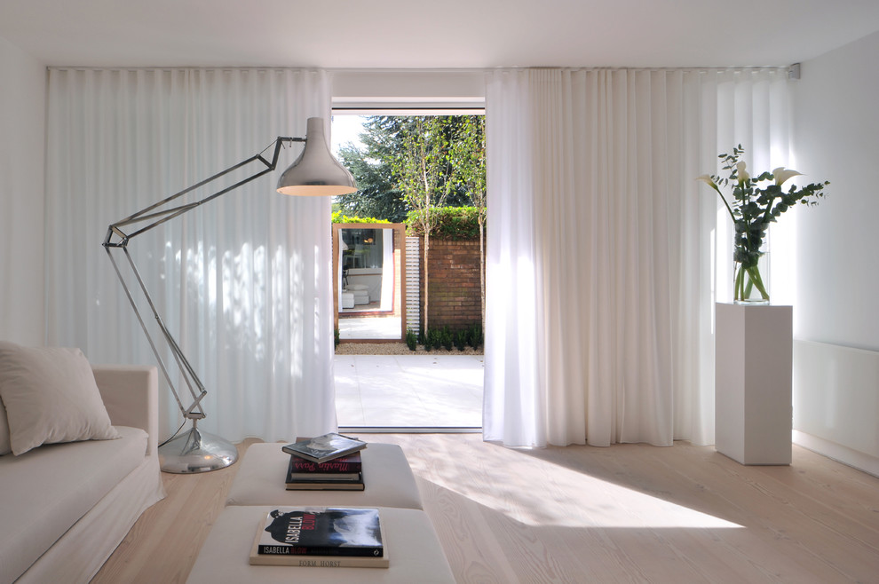 Inspiration pour un salon nordique de taille moyenne et ouvert avec un mur blanc et parquet clair.