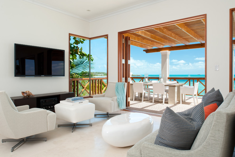 Immagine di un soggiorno tropicale con pareti bianche e TV a parete