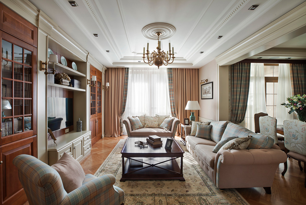 Ejemplo de salón para visitas abierto clásico sin chimenea con paredes beige, suelo de madera en tonos medios y televisor colgado en la pared