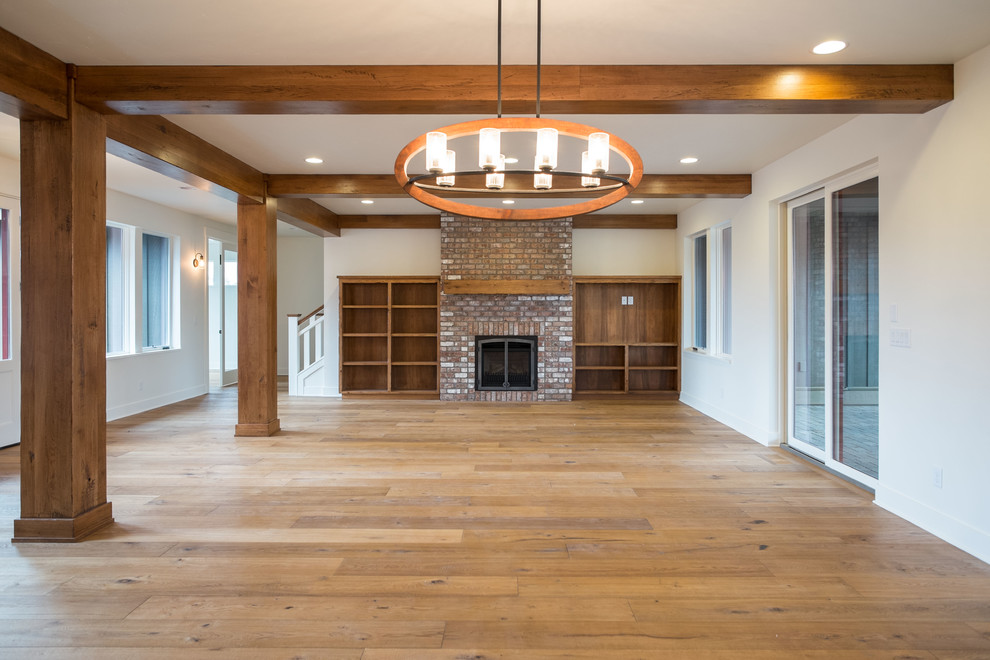 Example of a mid-sized transitional open concept medium tone wood floor living room design in Other with a brick fireplace and a media wall