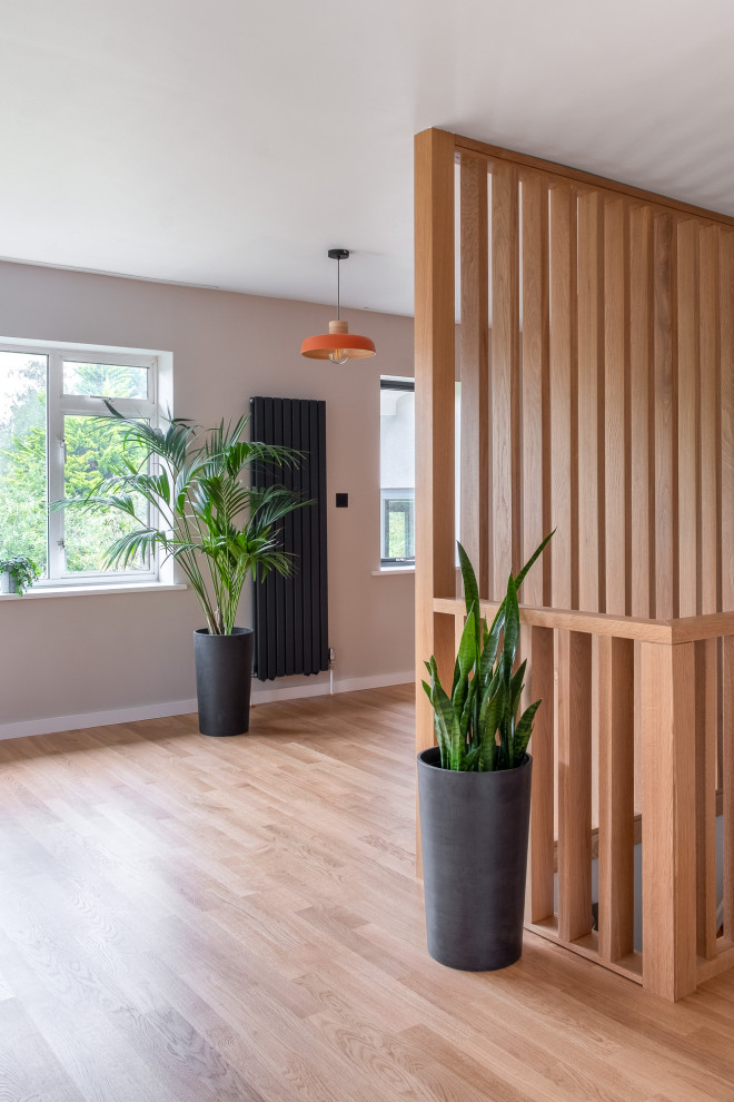 Idée de décoration pour un grand salon vintage ouvert avec un mur gris et un sol en bois brun.