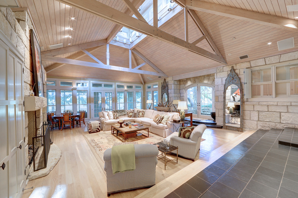 Foto de salón para visitas abierto de estilo de casa de campo con suelo de madera clara y piedra