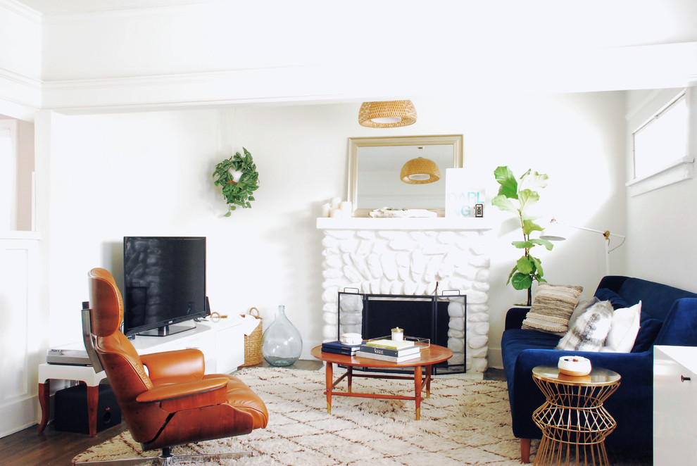 Repräsentatives, Kleines Mid-Century Wohnzimmer mit weißer Wandfarbe, dunklem Holzboden, Kamin, Kaminumrandung aus Stein, freistehendem TV und Steinwänden in Los Angeles