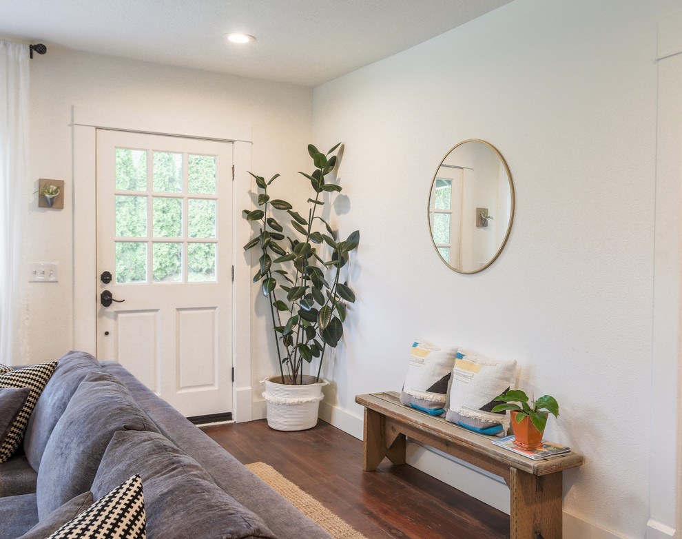 Idée de décoration pour un petit salon champêtre ouvert avec un mur blanc, un sol en bois brun, une cheminée standard, un manteau de cheminée en brique, un téléviseur fixé au mur et un sol marron.