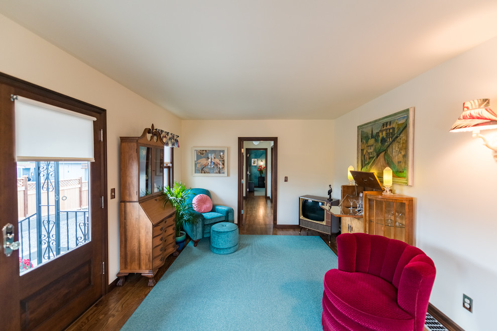 Mittelgroßes, Abgetrenntes Retro Wohnzimmer mit Hausbar, beiger Wandfarbe, braunem Holzboden und freistehendem TV in Seattle