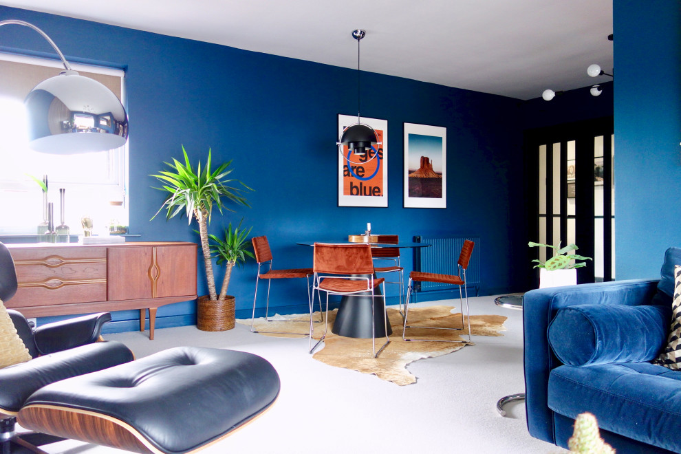 Idées déco pour un grand salon rétro ouvert avec un mur bleu, moquette, un téléviseur fixé au mur et un sol gris.