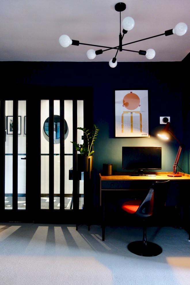 Modelo de salón abierto retro grande con paredes azules, moqueta, televisor colgado en la pared y suelo gris