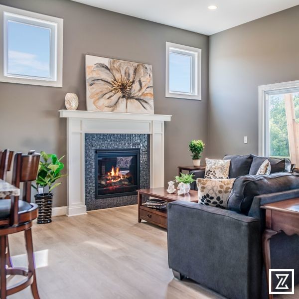 Inspiration for a small transitional open concept laminate floor and brown floor living room remodel in Other with beige walls, a standard fireplace, a tile fireplace and a wall-mounted tv