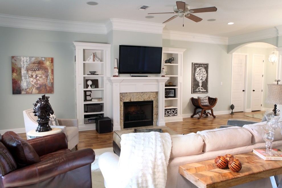 Пример оригинального дизайна: открытая гостиная комната среднего размера в стиле рустика с серыми стенами, светлым паркетным полом, стандартным камином, фасадом камина из дерева и телевизором на стене