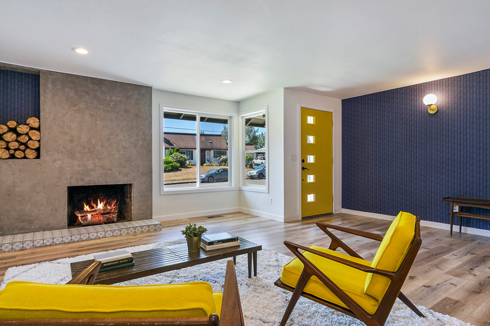 Foto di un grande soggiorno minimalista aperto con pareti bianche, pavimento in laminato, camino classico, cornice del camino in cemento e pavimento marrone