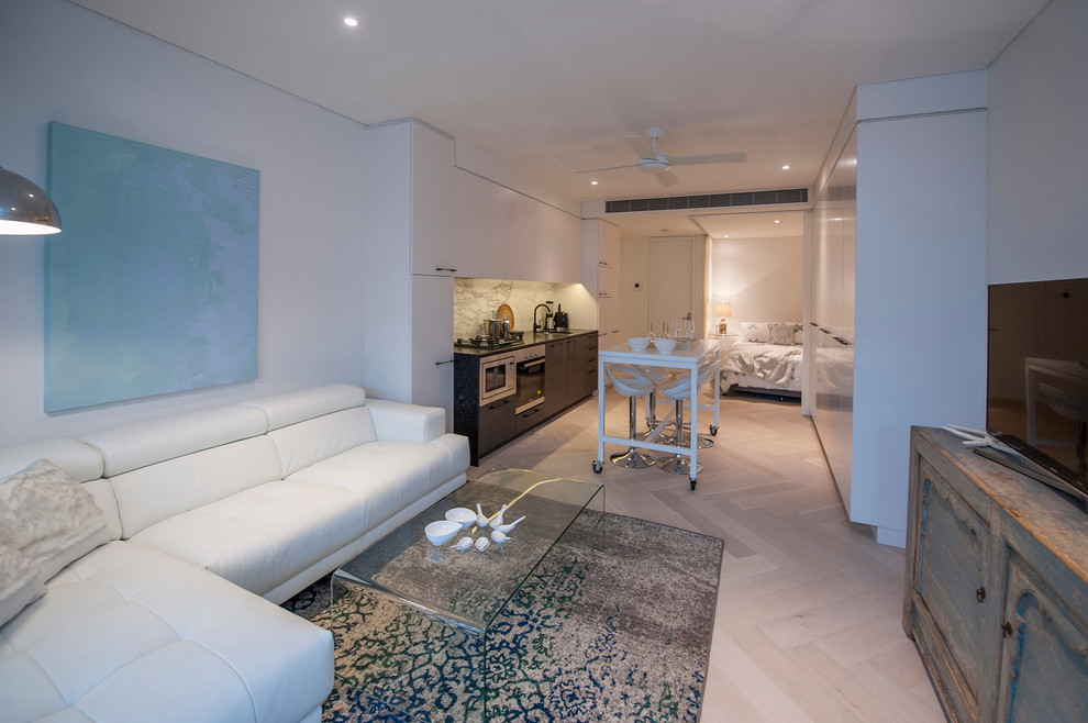 Idee per un soggiorno minimal di medie dimensioni e aperto con pareti bianche, parquet chiaro e nessun camino