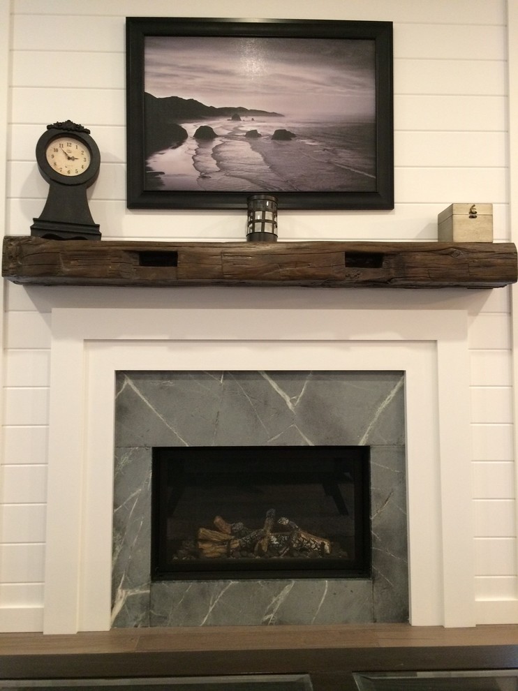 トロントにある高級な小さなラスティックスタイルのおしゃれなLDK (白い壁、無垢フローリング、標準型暖炉、石材の暖炉まわり、壁掛け型テレビ) の写真