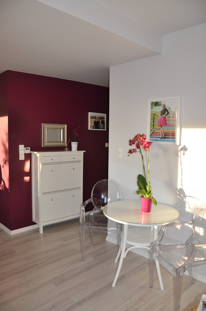 Aménagement d'un petit salon contemporain ouvert avec une salle de réception, parquet clair, un téléviseur indépendant et un mur rouge.