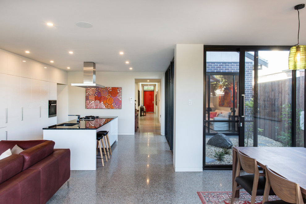 Imagen de salón con barra de bar abierto minimalista grande con paredes blancas y suelo de cemento