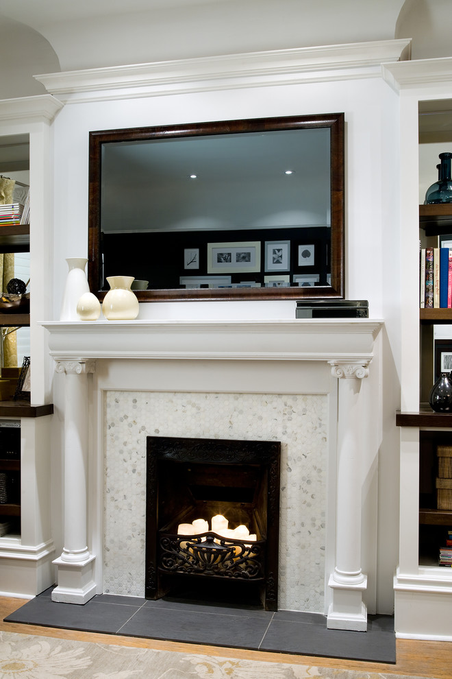 Example of a mid-sized transitional enclosed light wood floor and beige floor living room library design in Other with white walls, a standard fireplace, a wood fireplace surround and a concealed tv