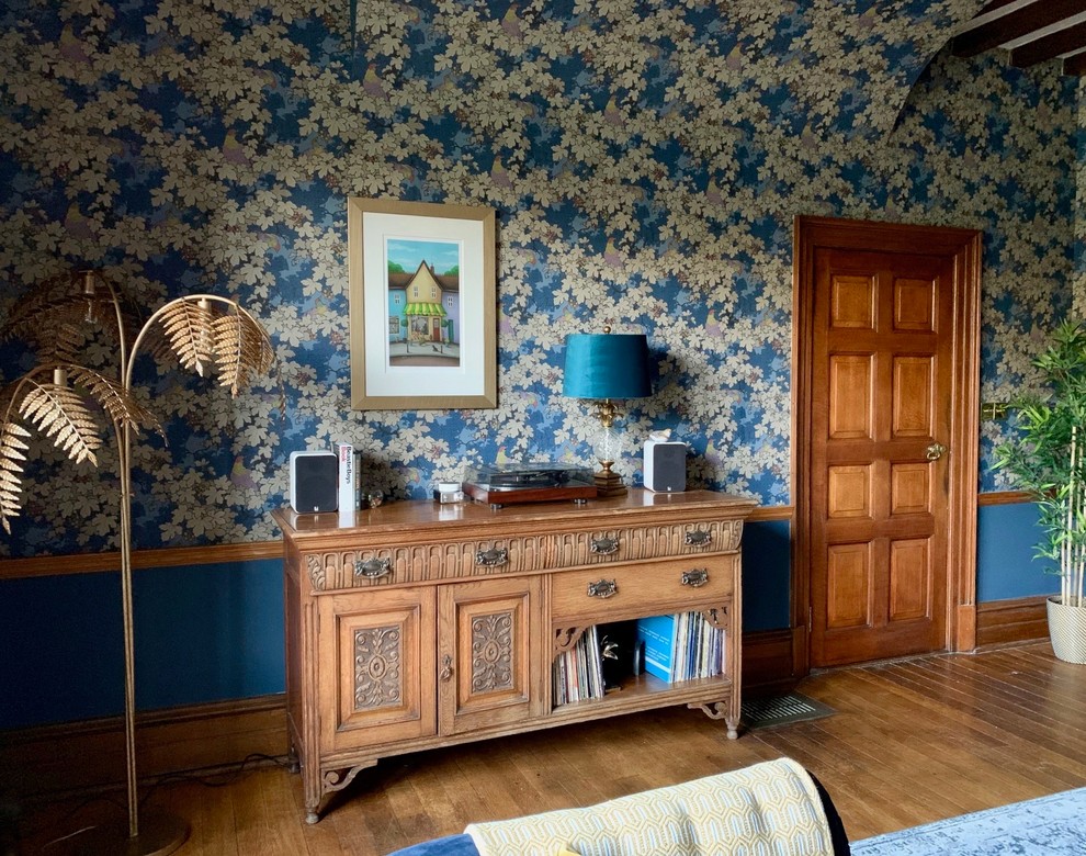Пример оригинального дизайна: огромная парадная, изолированная гостиная комната в стиле фьюжн с синими стенами, темным паркетным полом, стандартным камином, фасадом камина из камня и коричневым полом без телевизора