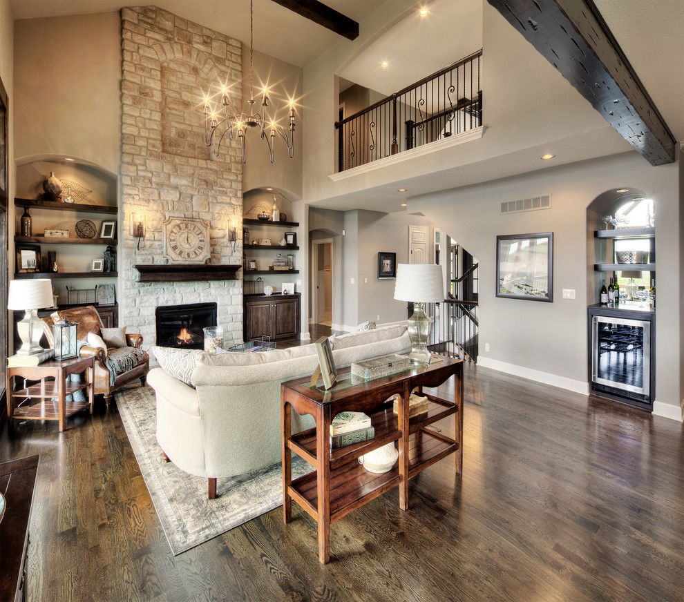 Expansive rustic formal open plan living room in Kansas City with white walls, medium hardwood flooring, a standard fireplace, a stone fireplace surround and a concealed tv.