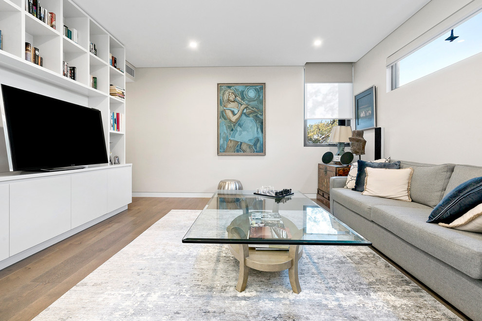 Immagine di un soggiorno design di medie dimensioni e chiuso con pareti beige, pavimento in legno massello medio, TV autoportante, pavimento marrone e sala formale