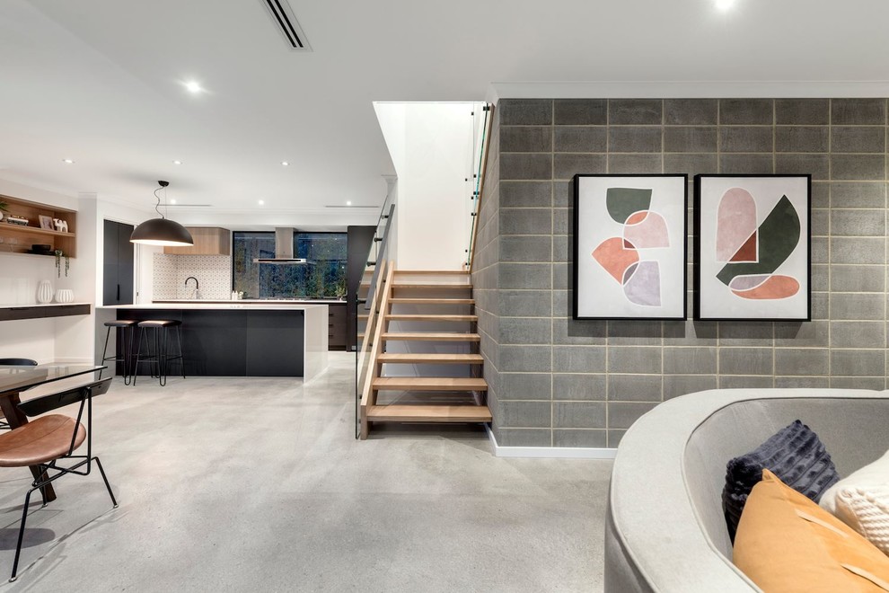 Idee per un grande soggiorno design aperto con pareti bianche, pavimento in cemento, TV a parete e pavimento grigio