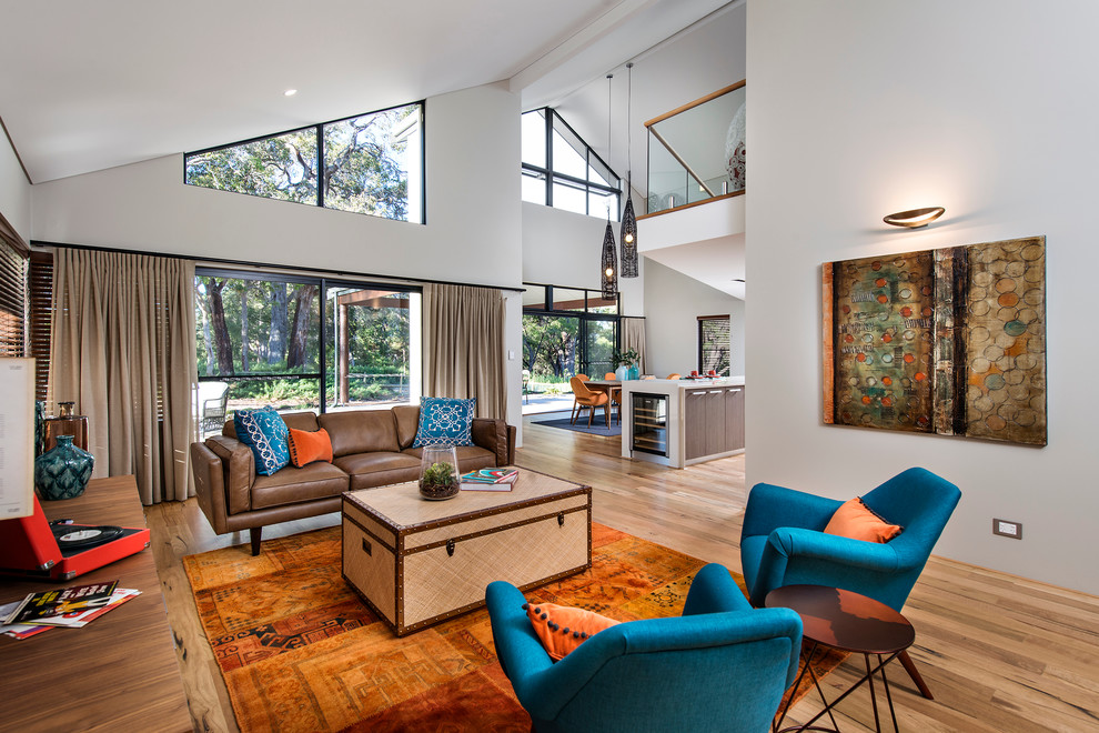Offenes Modernes Wohnzimmer ohne Kamin mit weißer Wandfarbe und braunem Holzboden in Perth