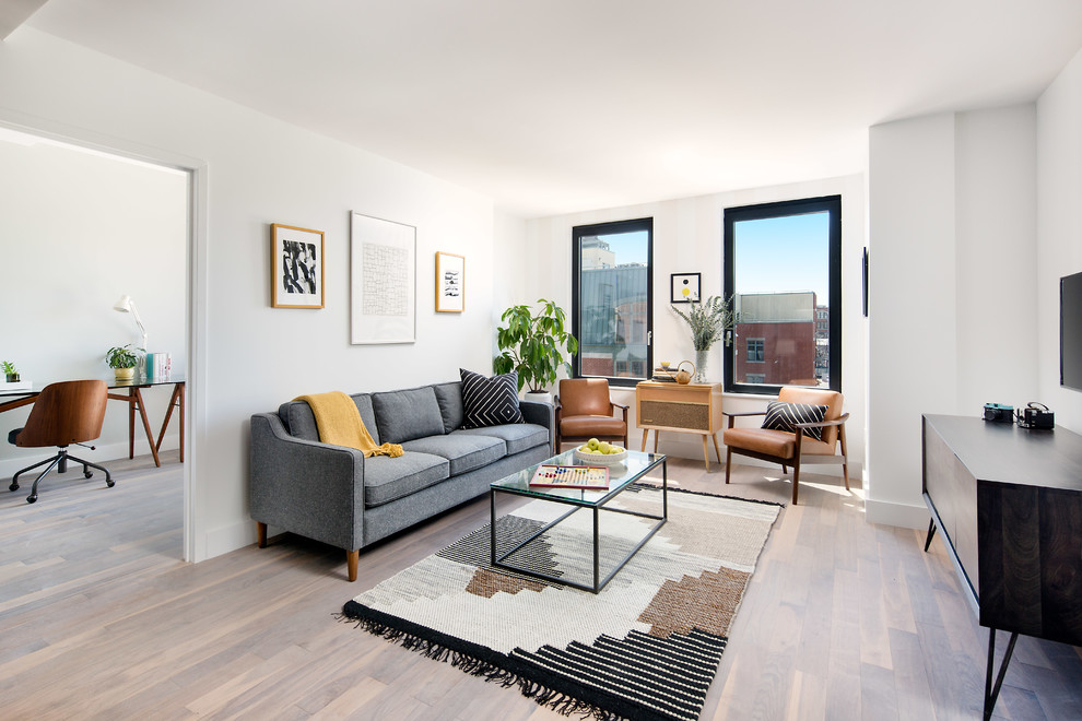 Mittelgroßes, Offenes Retro Wohnzimmer mit weißer Wandfarbe, TV-Wand und beigem Boden in New York