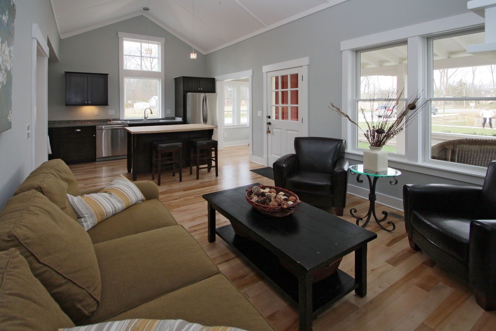This is an example of a traditional open plan living room in Indianapolis with grey walls and light hardwood flooring.