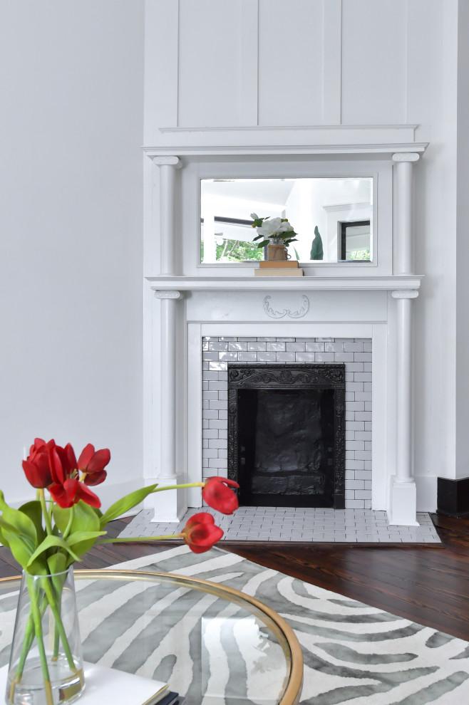 アトランタにある高級な中くらいなトラディショナルスタイルのおしゃれなLDK (白い壁、濃色無垢フローリング、コーナー設置型暖炉、タイルの暖炉まわり、茶色い床) の写真