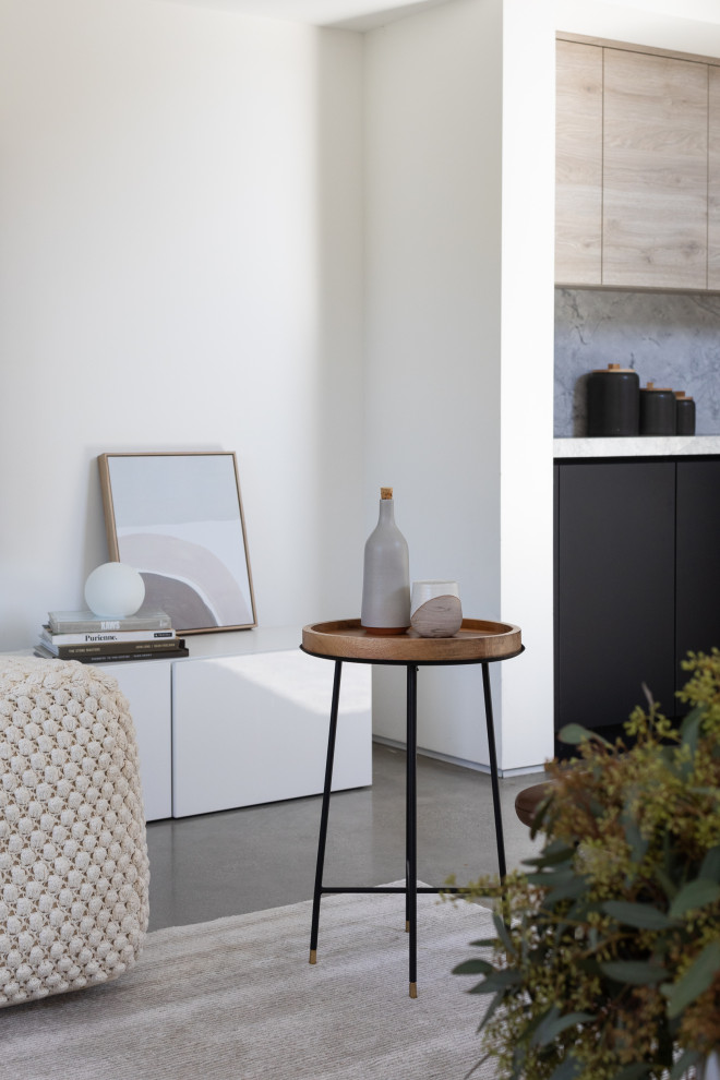 Diseño de salón abierto y abovedado minimalista pequeño sin chimenea con paredes blancas, suelo de cemento, televisor colgado en la pared y suelo gris