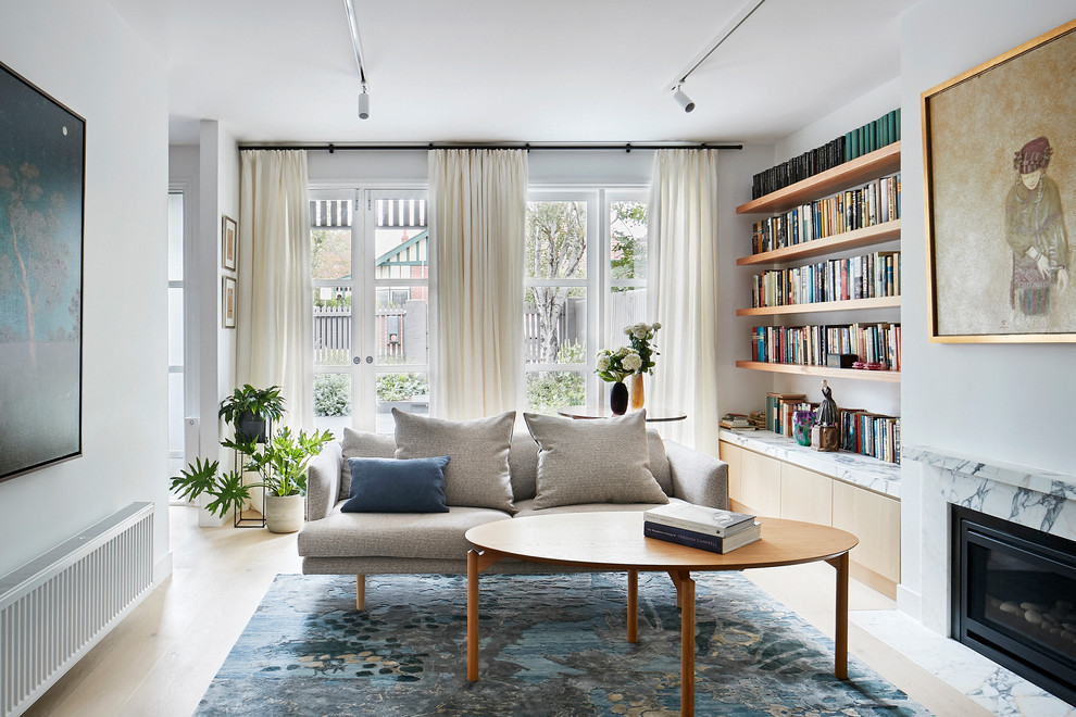 Mittelgroßes, Abgetrenntes Modernes Wohnzimmer mit weißer Wandfarbe, hellem Holzboden, Kamin, Kaminumrandung aus Stein und TV-Wand in Melbourne