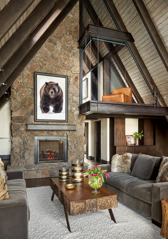 Inspiration for a rustic open plan living room in Denver with dark hardwood flooring, a standard fireplace, a stone fireplace surround and brown floors.