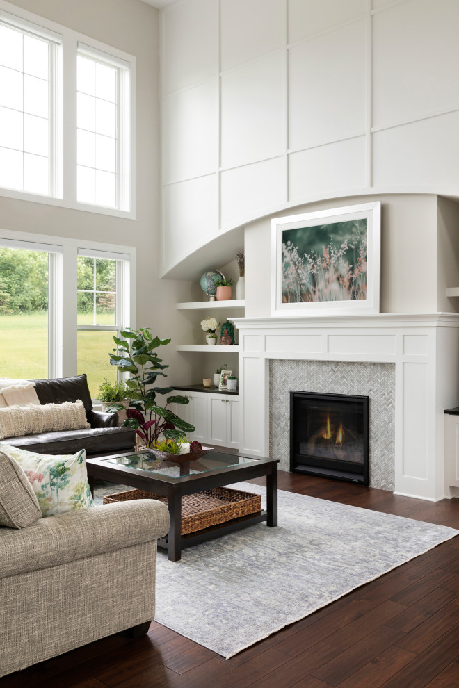 Medium sized classic open plan living room with grey walls, medium hardwood flooring, a standard fireplace, a tiled fireplace surround, a built-in media unit and brown floors.