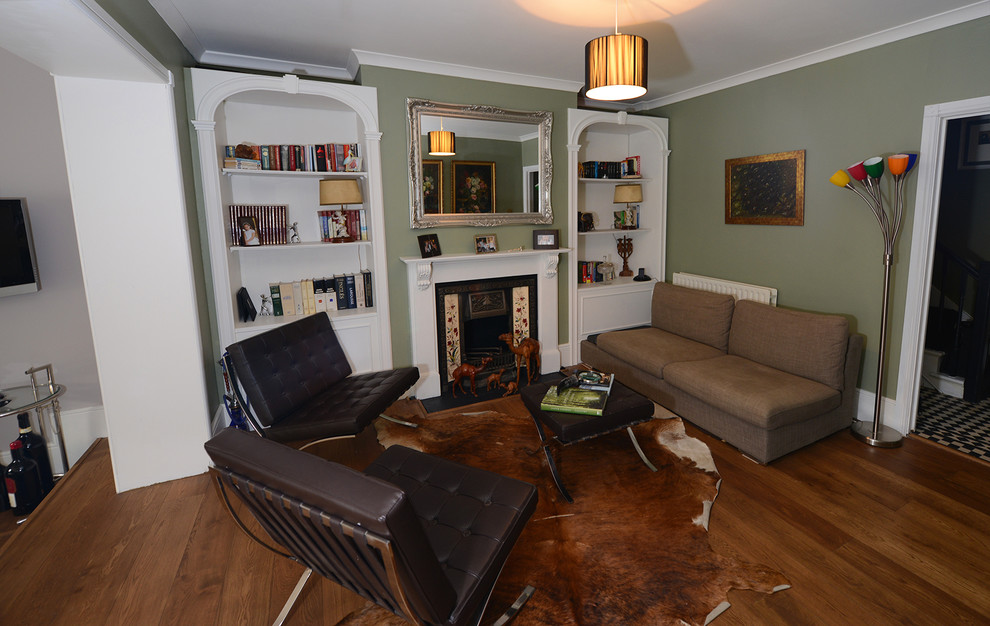 Photo of a medium sized open plan living room in London with green walls, dark hardwood flooring, a standard fireplace, a wooden fireplace surround and no tv.