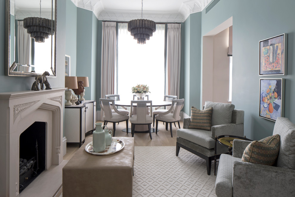 На фото: гостиная комната в стиле неоклассика (современная классика) с синими стенами, светлым паркетным полом и стандартным камином с