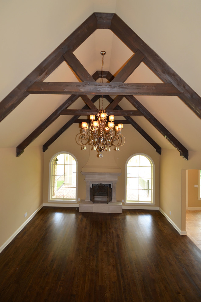 Example of a large classic enclosed dark wood floor living room design in Louisville with beige walls, a standard fireplace and a plaster fireplace