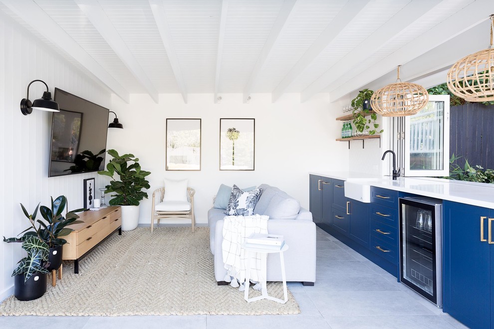 Идея дизайна: маленькая открытая гостиная комната в морском стиле с белыми стенами, телевизором на стене и серым полом для на участке и в саду