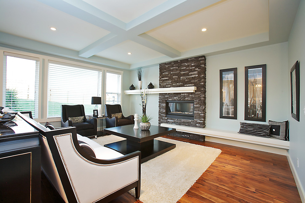 Photo of a bohemian living room in Calgary with a stone fireplace surround.