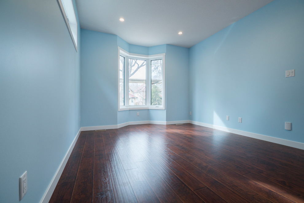 Réalisation d'un salon minimaliste ouvert avec un mur bleu, sol en stratifié et un sol marron.