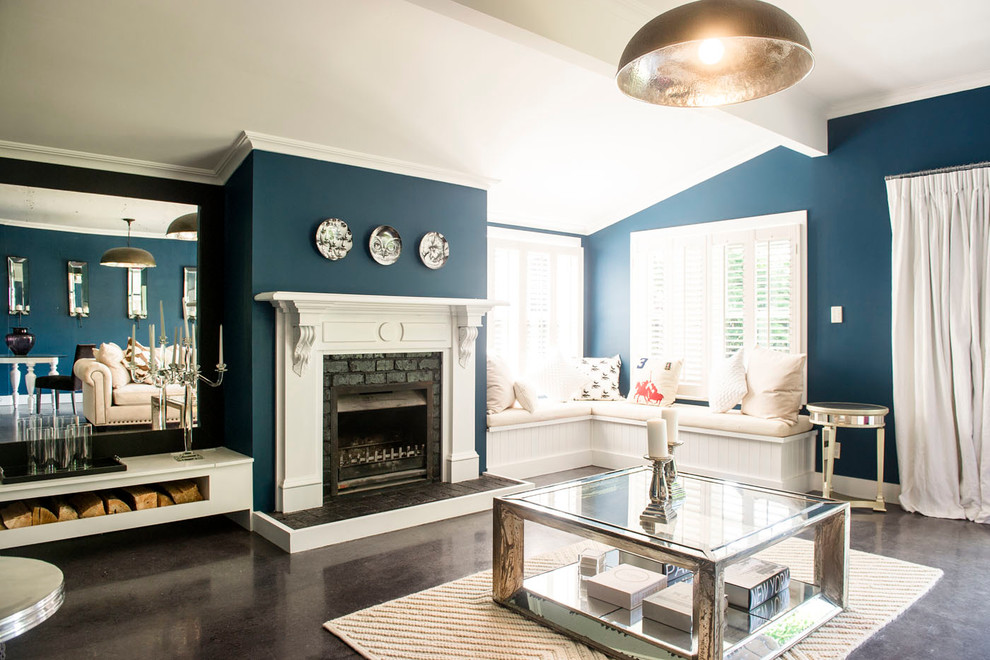 Aménagement d'un grand salon classique ouvert avec un mur bleu, sol en béton ciré, une cheminée standard, un manteau de cheminée en brique, aucun téléviseur et un sol gris.