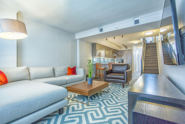 Mittelgroßes, Offenes Modernes Wohnzimmer ohne Kamin mit weißer Wandfarbe, braunem Holzboden und TV-Wand in Washington, D.C.