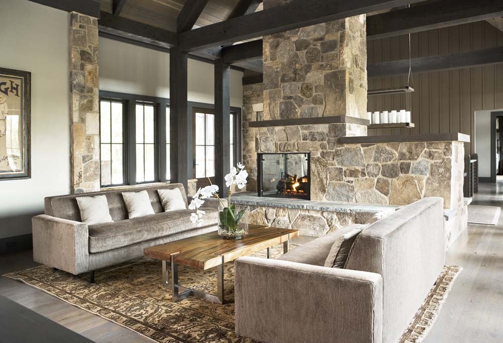 Living room - huge rustic formal and open concept light wood floor living room idea in Other with gray walls, a two-sided fireplace and a stone fireplace