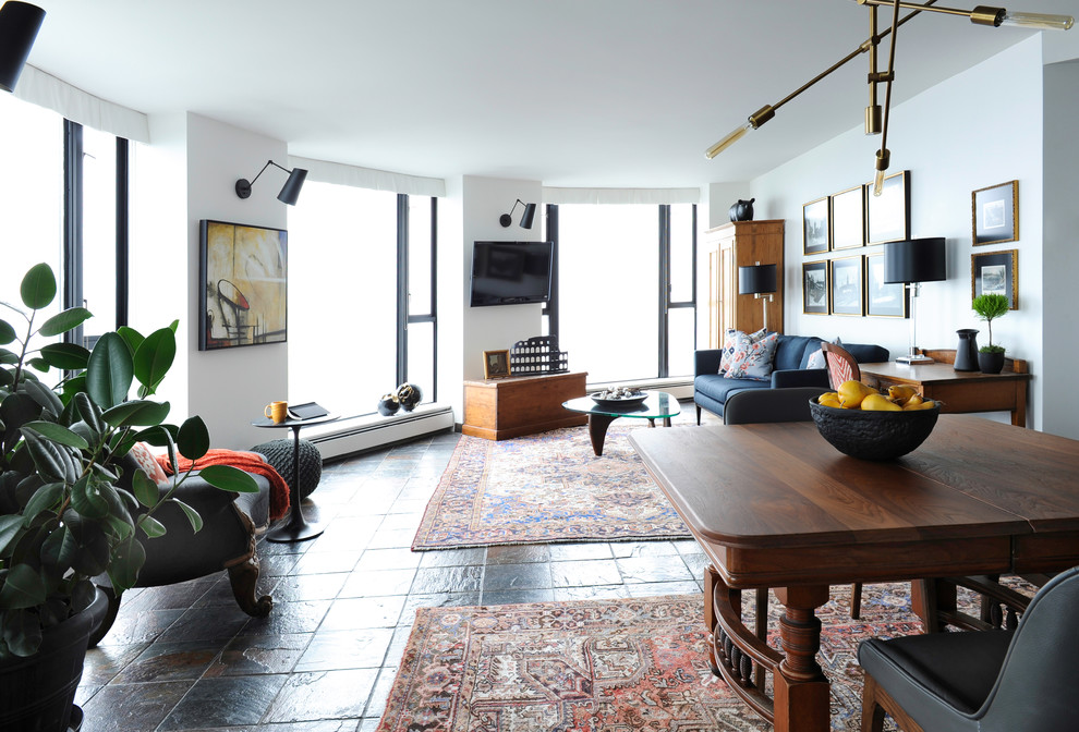 Foto di un soggiorno tradizionale di medie dimensioni e stile loft con pareti bianche, pavimento in ardesia e TV a parete