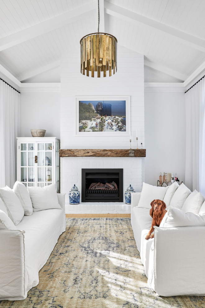 Landhausstil Wohnzimmer mit weißer Wandfarbe, Kamin, Kaminumrandung aus Backstein, Holzdielendecke und gewölbter Decke in Sonstige