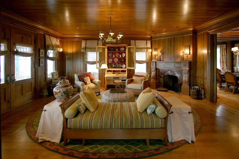 На фото: большая парадная гостиная комната в викторианском стиле с коричневыми стенами, паркетным полом среднего тона, угловым камином и фасадом камина из камня без телевизора с
